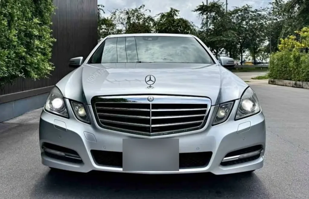 Front view of a silver Mercedes E250 CDI W212 sedan, an example of buying an old car with timeless design
