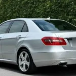 Buying an old car: rear view of a silver Mercedes E250 CDI W212 sedan with the E 250 CDI badge