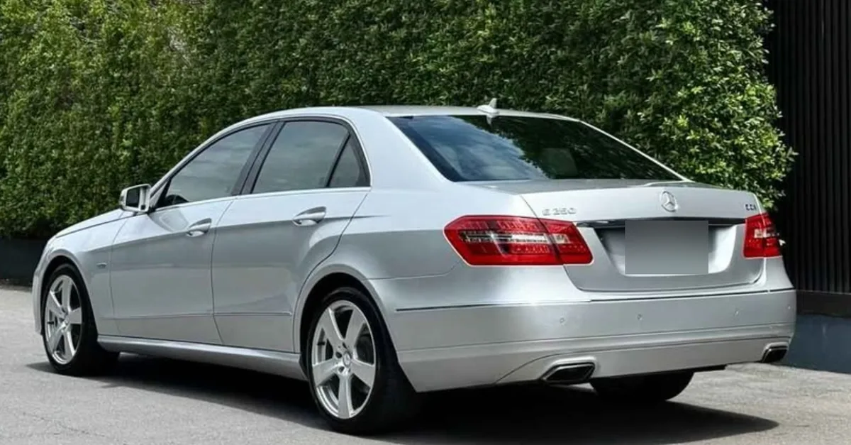 Buying an old car: rear view of a silver Mercedes E250 CDI W212 sedan with the E 250 CDI badge