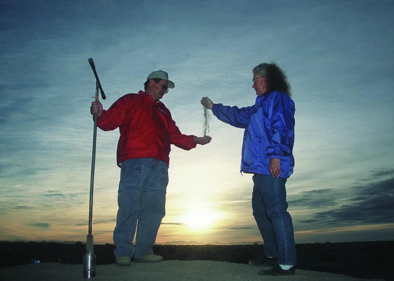 Soil scientists with a soil auger checking a sample on rural land