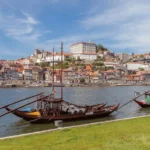 Cost of living abroad: rabelo boats on the Douro river in front of the Ribeira district of Porto, Portugal
